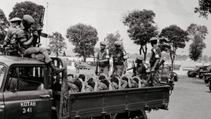 Para prajurit bersenjata mengangkut para terduga anggota Pemuda Rakyat, pada 10 Oktober 1965. (BETTMANN/GETTY IMAGES)