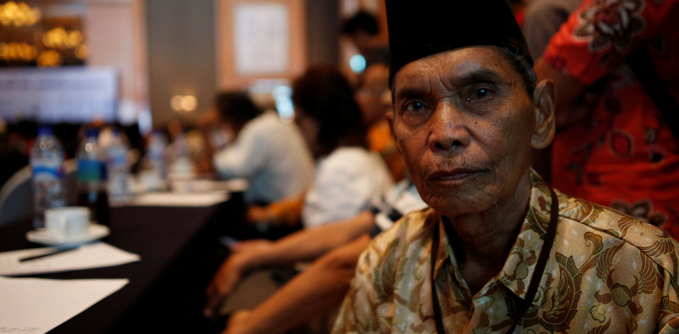 Abdurrashim, 72, poses for a photograph while attending a state-backed event on the controversial anti-communist purge of 1965 in Jakarta,